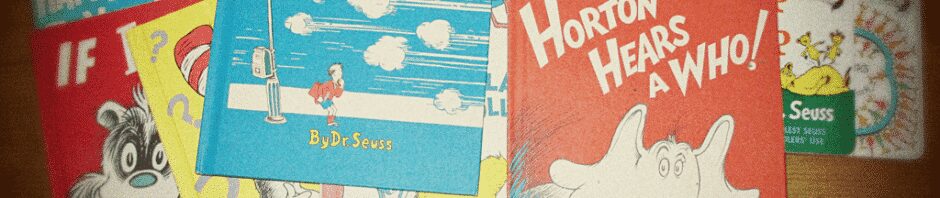 A pile of children books written by Dr. Seuss on a brown table