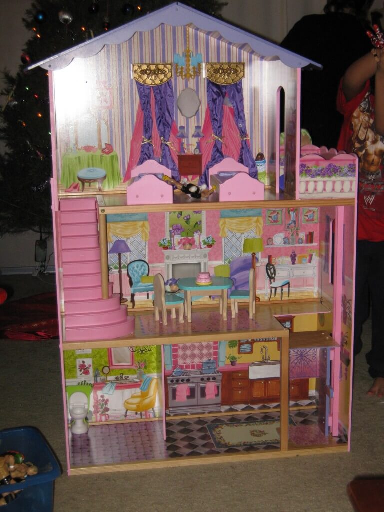 A 3 story dollhouse, painted in pastel colors, with toy furniture. A wrestling action figure awakes between two single beds. To the right, he sees a door to a balcony. He looks out and discovers he's three stories high. He goes inside and crosses to the left side and finds a staircase leading to a living room. There's a table with two chairs and an uneaten birthday cake. He continues to the right side finding an elevator lift. He takes it to the bottom floor to a large kitchen with a small bathroom on the left. He exits the home and wonders, "Where did everyone go?" He sees a large blue bucket and climbs up to the highest point where he falls in and finds his pals, fast asleep.