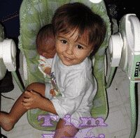 Toddler sitting next to infant sibling on a baby swing