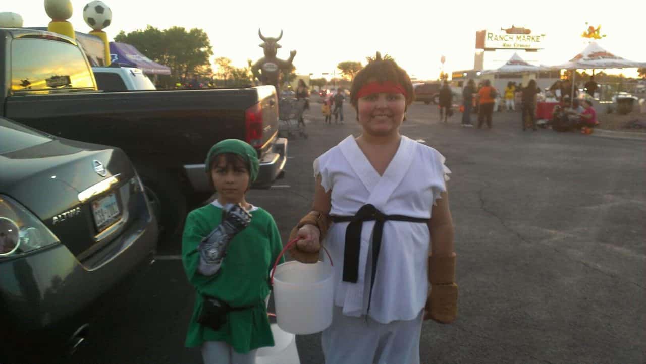 Two young children in Halloween costumes. One as Link from the Zelda game franchise while the other is Ryu from the Street Fighter game franchise