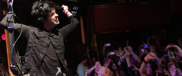 Lead guitarist, Billy Joe Armstrong, playing the guitar behind his head.