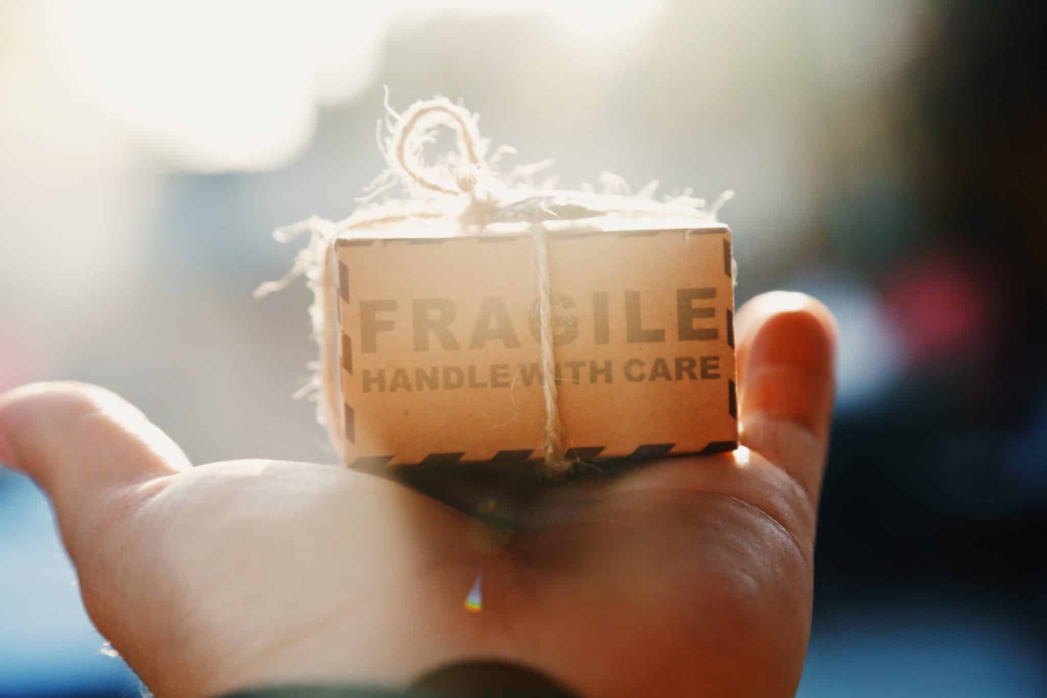 person holding box marked fragile