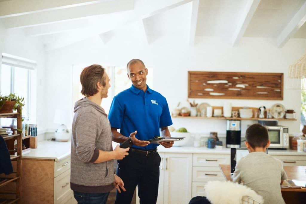 A Best buy employee providing an in-home consultation in a homeowner's living room