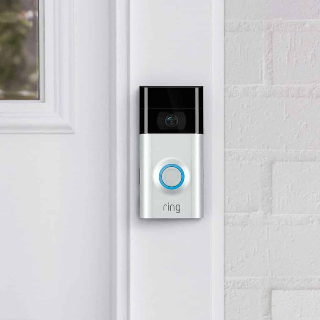 Ring doorbell installed on the white frame of a front door entrance